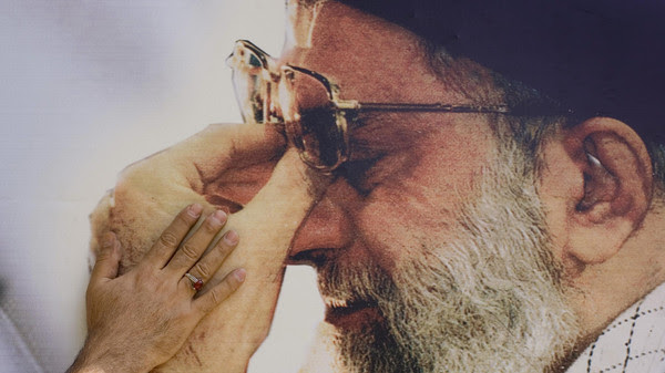 Iranian digital printing technician pastes picture of Iran's Supreme Leader Ayatollah Ali Khamenei in Khomeini Mausoleum in Tehran