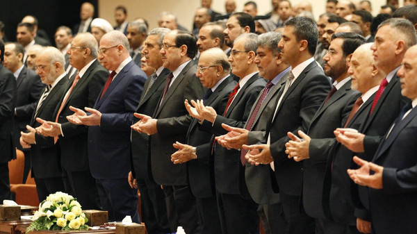 Members of the new Iraqi parliament recite verses from the Koran at the parliament headquarters in Baghdad