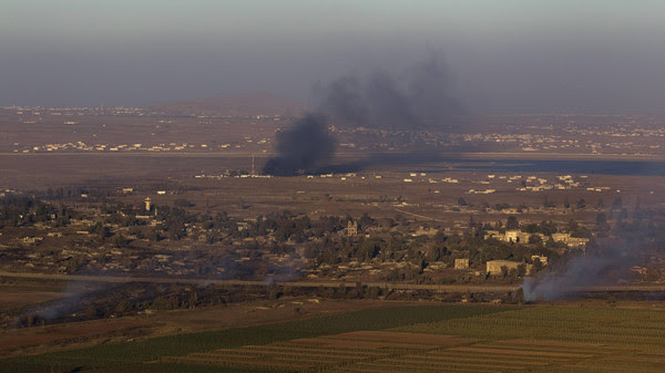 Smoke rises on both sides of the line dividing the Israeli-occupied Golan Heights from Syria during fighting near the Quneitra border crossing
